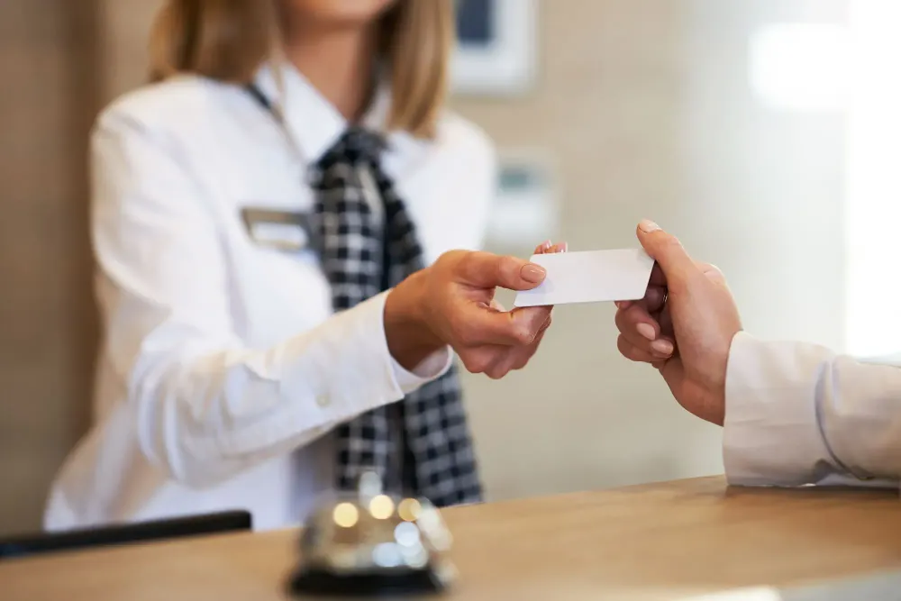 Receptionist handing over a hotel key to a guest